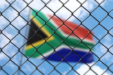 South African flag seen through a security fence — representing a border ban
